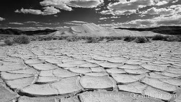 Arid and barren mud flats, dried mud, with the tall Eureka Dunes in the distance, Eureka Valley, Death Valley National Park, California