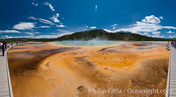 Bacteria mats and Grand Prismatic Spring.  The orange color is due to bacteria which thrive only on the cooler fringes of the hot spring, while the hotter center of the spring hosts blue-colored bacteria, Midway Geyser Basin, Yellowstone National Park, Wyoming