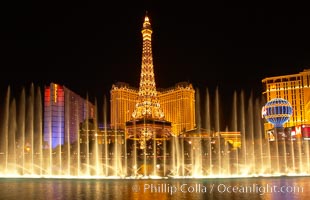 The Bellagio Hotel fountains light up the reflection pool as the half-scale replica of the Eiffel Tower at the Paris Hotel in Las Vegas rises above them, at night