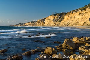 Black's Beach sea cliffs, sunset, looking north from Scripps Pier with Torrey Pines State Reserve in the distance, La Jolla, California