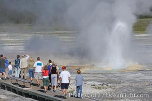 Visitors watch Clepsydra Geyser erupts almost continuously, reaching heights of  feet.  Its name is Greek for water clock, since at one time it erupted very regularly with a three minute interval.  Lower Geyser Basin, Yellowstone National Park, Wyoming