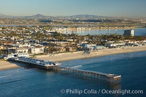 Crystal Pier, 872 feet long and built in 1925, extends out into the Pacific Ocean from the town of Pacific Beach.  Mission Bay and downtown San Diego are seen in the distance