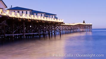 The Crystal Pier and Pacific Ocean at sunrise, dawn, waves blur as they crash upon the sand.  Crystal Pier, 872 feet long and built in 1925, extends out into the Pacific Ocean from the town of Pacific Beach