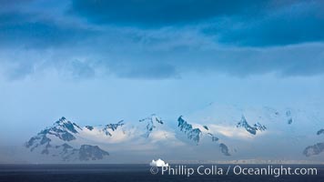 Distant icebergs, mountains, clouds, ocean at dawn, in the South Shetland Islands, near Deception Island