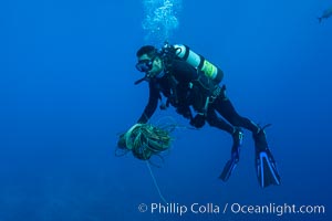 Diver collecting fishing line and debris from coral reef, Clipperton Island