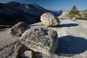 Glacial erratic boulders atop Olmsted Point, with the massive granite monoliths Half Dome and Clouds Rest in the background. Erratics are huge boulders left behind by the passing of glaciers which carved the granite surroundings into their present-day form.  When the glaciers melt, any boulders and other geologic material that it was carrying are left in place, sometimes many miles from their original location, Yosemite National Park, California