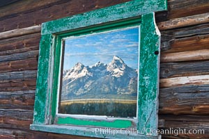 Teton Range reflection, in window of old barn in Grand Teton National Park