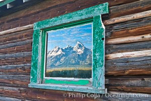 Teton Range reflection, in window of old barn in Grand Teton National Park