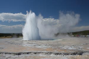 Great Fountain Geyser erupting.  Great Fountain Geyser, a fountain-type geyser, can reach heights of 200 feet, one of the largest geysers in the world.  It has a large vent (16 feet across) situated amid wide sinter terraces that act as reflecting pools as the geyser slows fills prior to its eruption.  Its interval and duration vary widely.  It typically erupts in a series of bursts, each separately by a few minutes.  Firehole Lake Drive, Lower Geyser Basin, Yellowstone National Park, Wyoming