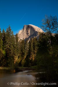 Half Dome and star trails, at night, viewed from Sentinel Bridge, illuminated by the light of the full moon, Yosemite National Park, California