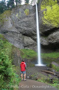 A hiker admires Latourelle Falls, in Guy W. Talbot State Park, drops 249 feet through a lush forest near the Columbia River, Columbia River Gorge National Scenic Area, Oregon