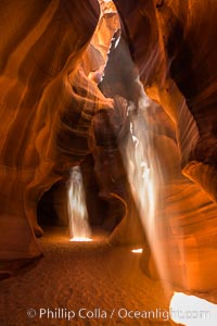 Light Beam in Upper Antelope Slot Canyon.  Thin shafts of light briefly penetrate the convoluted narrows of Upper Antelope Slot Canyon, sending piercing beams through the sandstone maze to the sand floor below, Navajo Tribal Lands, Page, Arizona