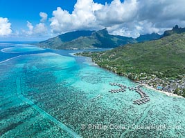 Moorea rises above its lagoon and barrier reef, French Polynesia, aerial view. Cooks Bay lies in the distance