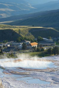 New Blue Spring steams in the cold morning air with Mammoth Hot Springs Inn in the distance, Yellowstone National Park, Wyoming