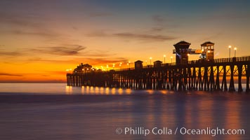 Oceanside Pier at sunset, clouds with a brilliant sky at dusk, the lights on the pier are lit
