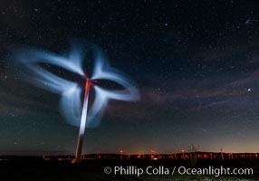 Stars rise above the Ocotillo Wind Turbine power generation facility, with a flashlight illuminating the turning turbine blades