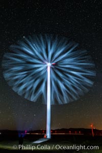 Stars rise above the Ocotillo Wind Turbine power generation facility, with a flashlight illuminating the turning turbine blades