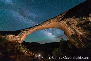 Owachomo Bridge and Milky Way.  Owachomo Bridge, a natural stone bridge standing 106' high and spanning 130' wide,stretches across a canyon with the Milky Way crossing the night sky, Natural Bridges National Monument, Utah