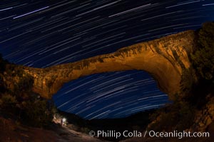 Owachomo Bridge and Star Trails, at night.  Owachomo Bridge, a natural stone bridge standing 106' high and spanning 130' wide,stretches across a canyon with the Milky Way crossing the night sky, Natural Bridges National Monument, Utah