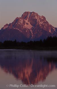 Mount Moran in the Teton Range is reflected at sunrise in a sidewater of the Snake River at Oxbow Bend, summer, Grand Teton National Park, Wyoming