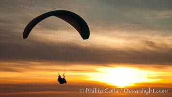 Paraglider soaring at Torrey Pines Gliderport, sunset, flying over the Pacific Ocean, La Jolla, California