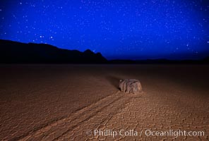 Racetrack sailing stone and stars at night. A sliding rock of the Racetrack Playa. The sliding rocks, or sailing stones, move across the mud flats of the Racetrack Playa, leaving trails behind in the mud. The explanation for their movement is not known with certainty, but many believe wind pushes the rocks over wet and perhaps icy mud in winter, Death Valley National Park, California