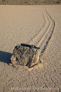 Sailing stone on the Death Valley Racetrack playa.  The sliding rocks, or sailing stones, move across the mud flats of the Racetrack Playa, leaving trails behind in the mud.  The explanation for their movement is not known with certainty, but many believe wind pushes the rocks over wet and perhaps icy mud in winter, Death Valley National Park, California