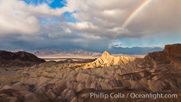 Rainbow and clearing storm clouds, sunrise light on Manly Beacon, Zabriskie Point, Death Valley National Park, California