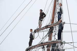 Crew members stand in the rigging of the tall ship Hawaiian Chieftain, Morro Bay, California