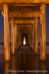 Full moon setting over the Pacific lights the inside of Scripps Pier, La Jolla, California