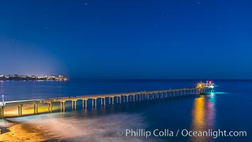 Scripps Institution of Oceanography Research Pier at night, lit with stars in the sky, old La Jolla town in the distance