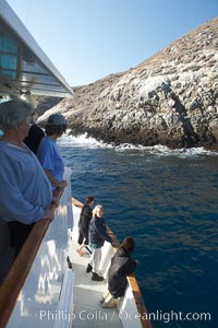 Visitors watch sea lions along the coast of Santa Barbara Island, part of the Channel Islands National Marine Sanctuary.  Santa Barbara Island lies 38 miles offshore of the coast of California, near Los Angeles