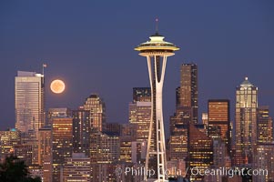 Full moon rises over Seattle city skyline at dusk, Space Needle at right