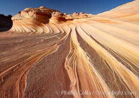 The Second Wave at sunset.  The Second Wave, a curiously-shaped sandstone swirl, takes on rich warm tones and dramatic shadowed textures at sunset.  Set in the North Coyote Buttes of Arizona and Utah, the Second Wave is characterized by striations revealing layers of sedimentary deposits, a visible historical record depicting eons of submarine geology, Paria Canyon-Vermilion Cliffs Wilderness