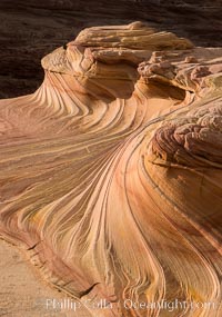 The Second Wave at Sunset, Vermillion Cliffs. The Second Wave, a curiously-shaped sandstone swirl, takes on rich warm tones and dramatic shadowed textures at sunset. Set in the North Coyote Buttes of Arizona and Utah, the Second Wave is characterized by striations revealing layers of sedimentary deposits, a visible historical record depicting eons of submarine geology, Paria Canyon-Vermilion Cliffs Wilderness