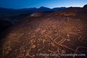 Sky Rock at night, light by moonlight with stars in the clear night sky above.  Sky Rock petroglyphs near Bishop, California. Hidden atop an enormous boulder in the Volcanic Tablelands lies Sky Rock, a set of petroglyphs that face the sky. These superb examples of native American petroglyph artwork are thought to be Paiute in origin, but little is known about them