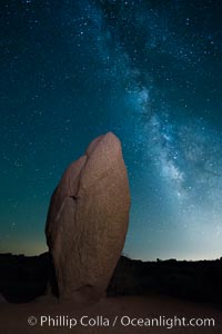 Standing stone and Milky Way, stars fill the night sky, Joshua Tree National Park, California