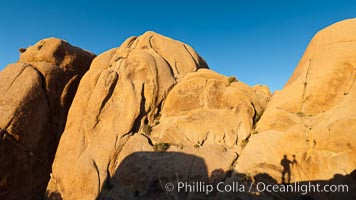 Sunrise on stone boulders, Joshua Tree National Park, desert southwest, photographer's shadow