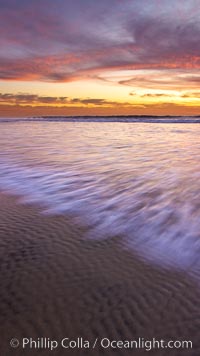 Sunset and incoming surf, gorgeous colors in the sky and on the ocean at dusk, the incoming waves are blurred in this long exposure, Carlsbad, California