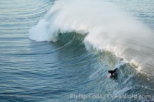 Bodyboarders tackle big waves at Oceanside Pier, sunset. Giant surf and big waves nail Southern California, December 21, 2005