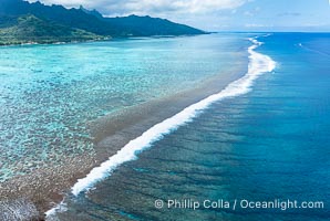 Waves break on Moorea's Barrier Reef, with shallow reef flat and protected lagoon to the left and open ocean to the right