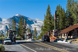 A car enters the stunning High Sierra entrance to Yosemite National Park at the summit of Tioga Pass. Mammoth Peak is seen in the background. A lucky park ranger, whose office is perhaps more beautiful than any other in the world, greets each car as it passes through. Tuolumne Meadows area of Yosemite National Park