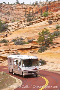 A motorhome recreational vehicle RV travels through the red rocks of Zion National Park