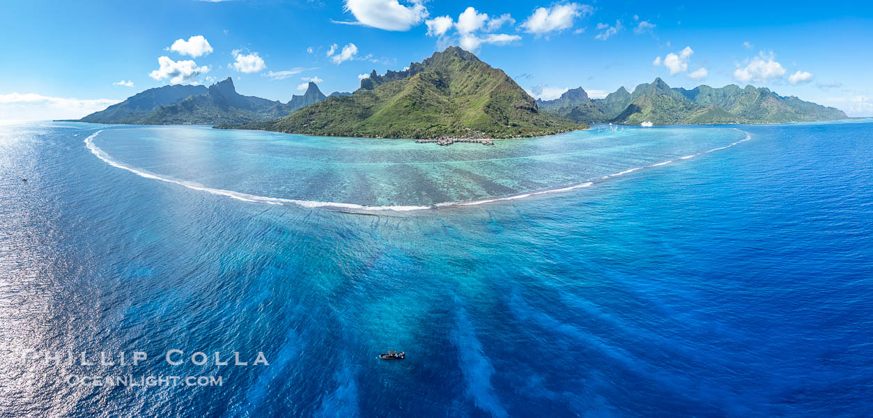 Barrier Reef around Moorea Island, French Polynesia. The outer reef slope is seen adjacent to deep blue oceanic water with white waves breaking against the reef edge. Next, a wide shallow reef flat occurs dotted with coral bommies. Inside of that, a shallow protected lagoon is formed against the island.  Tall, rugged, eroded mountains are seen hinting at the age of the ancient volcano that originally formed the island and that is now sinking back down, leaving the encircling reef behind. France, natural history stock photograph, photo id 40677