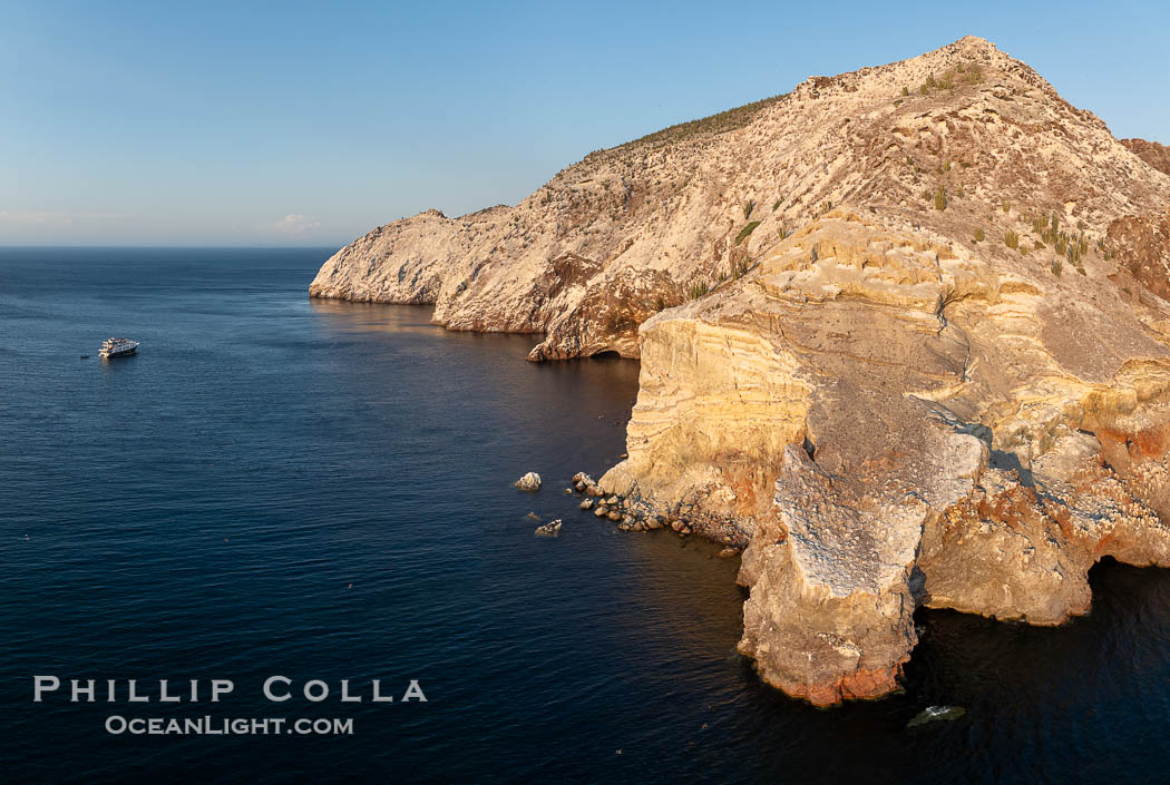 Rugged Terrain of Isla San Pedro Martir, Sea of Cortez. Aerial photo. The large bird population deposits enormous quantities of guano on the island, resulting in the white appearance of the island contrasted with sparse vegetation. In the late 19th and early 20th century guano was heavily mined off the island and shipped as far as Europe for use as fertilizer. San Pedro Martir is seldom visited, having near vertical sides leaving only questionable fair weather anchorages in two locations. Landing access was possible near a small isthmus in the southeast of the island, but is now forbidden. In 2005, the island was classified along with 244 others as a World Heritage Site by UNESCO, and included in the Islands and Protected Areas of the Gulf of California. Sonora, Mexico, natural history stock photograph, photo id 40401